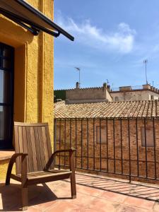 una sedia in legno seduta su un balcone con recinto di Apartament Can Callis a Castelló d'Empúries