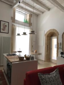 a kitchen and living room with a red couch at Le Stanze di Carlo in Syracuse