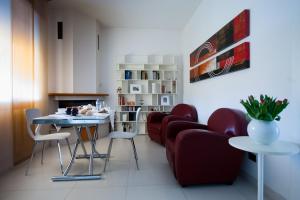a waiting room with red chairs and a table at Daniela B&B Fiera in Pero