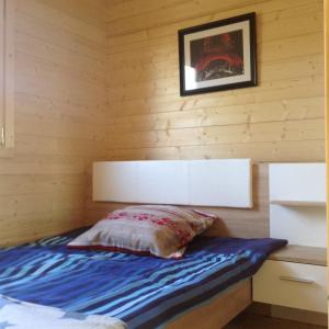 ミコワイキにあるKameralne domki w Mikolajkachの木製の壁のドミトリールームのベッド1台分です。