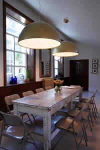 a large wooden table with chairs and two lights at The Chapel Boutique Bed and Breakfast in Harrogate