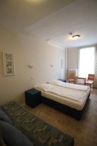 a bedroom with two beds and a couch in it at Pension am Rathaus in Hamburg