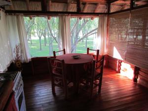 a table and chairs in a room with a window at Cabañas Manantiales de Obligado in San Pedro +21 photos