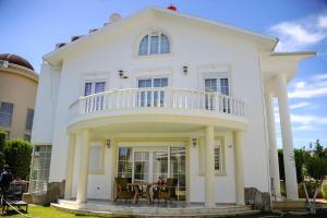 Casa blanca con balcón y mesa en Penelope Villa, en Belek