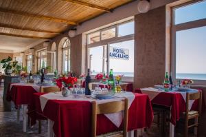 a dining room with tables with red tablecloths at Hotel Angelino in Ischia