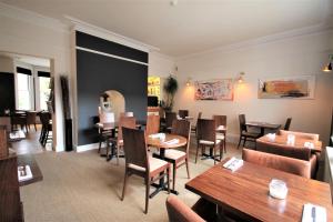 a restaurant with wooden tables and chairs and a dining room at Andover House Hotel & Restaurant - Adults only in Great Yarmouth +50 photos
