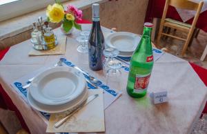 a table with plates and wine bottles on it at Hotel Angelino in Ischia