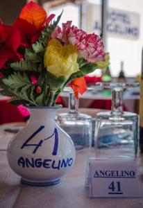 a vase filled with flowers sitting on a table at Hotel Angelino in Ischia