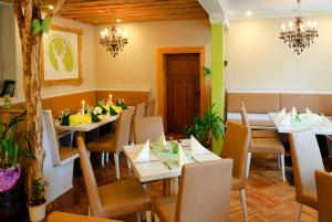 ein Restaurant mit weißen Tischen, Stühlen und Kerzen in der Unterkunft Apartmenthaus Reichelt in Göda
