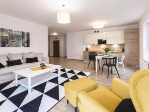 a living room with a couch and a table at VacationClub - Solna Apartment C103 in Kołobrzeg