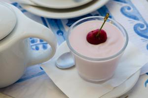 a glass of milk with a cherry in it at Hotel Angelino in Ischia