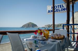 a table with food and a view of the ocean at Hotel Angelino in Ischia