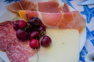 a plate of food with meat grapes and cheese at Hotel Angelino in Ischia