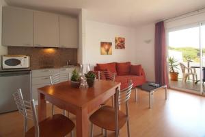cocina y sala de estar con mesa y sofá en Aparthotel Arenal en Pals