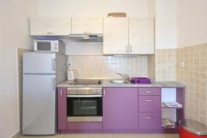 a kitchen with purple cabinets and a white refrigerator at Be-Bu-Mar Apartments in Sveti Filip i Jakov