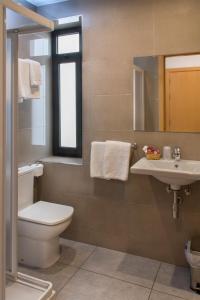 uma casa de banho com um WC, um lavatório e um espelho. em Hostal Portofino em Arenys de Mar