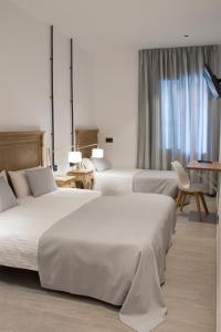 A bed or beds in a room at Hostal Portofino