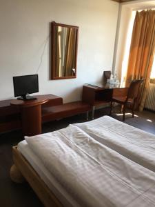 Schlafzimmer mit einem Bett und einem Schreibtisch mit einem Computer in der Unterkunft Hotel Zollhof in Hamburg