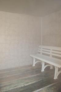 a white bench sitting next to a wall at Hotel Angelino in Ischia