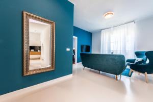 a living room with blue walls and a mirror at Aquamarine Sea View Apartment in Zadar