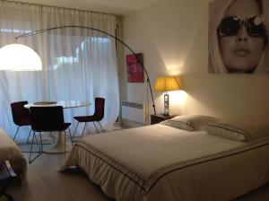 圣特罗佩BRIGITTE Studio centre Saint Tropez parking piscine wifi vue mer的卧室配有一张壁挂式太阳镜的床 更多34张照片