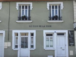 un edificio con dos ventanas y una puerta blanca en Le Clos de la tour, en La Tour-du-Pin