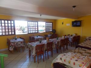 塔曼達雷的住宿－Pousada Bom Jesus，用餐室设有桌椅和窗户。