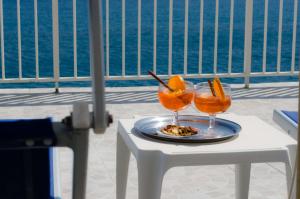 a table with two glasses of orange juice on it at Hotel Angelino in Ischia