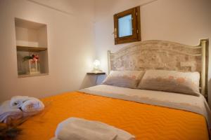 アルベロベッロにあるIl Trullo di Mastro Stefanoのベッドルーム1室(大型ベッド1台、オレンジの毛布付)