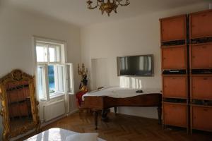 1 dormitorio con 1 cama y TV en la pared en Sarah's Altstadt Oase Salzburg, en Salzburgo