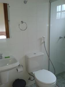 a white bathroom with a toilet and a sink at Pousada Ouro do Vintem in Conceição do Mato Dentro