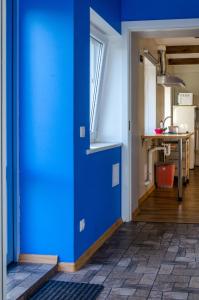 a blue door in a room with a kitchen at Colourfull fence apartment in Liepāja