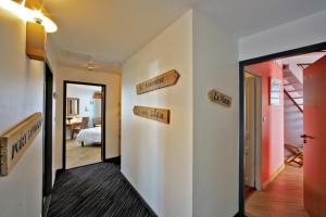 a hallway with directional signs on the walls at Logis Hôtel La Chaize in Noirmoutier-en-l'lle