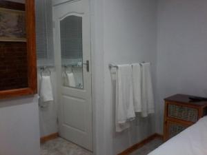 a bathroom with a white door and white towels at Aliwal Villa Guest Lodge in Aliwal North +51 photos
