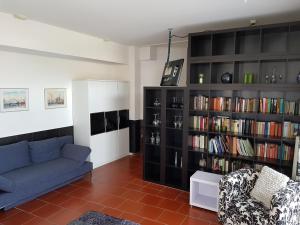 ein Wohnzimmer mit Sofa und Bücherregal in der Unterkunft Ferienwohnung Cuxhaven in Cuxhaven