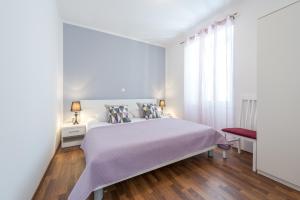 a white bedroom with a bed and a window at Fora Apartments in Dubrovnik