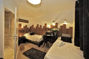 a hotel room with two beds and a desk and a room with at Logis Hôtel La Chaize in Noirmoutier-en-l'lle