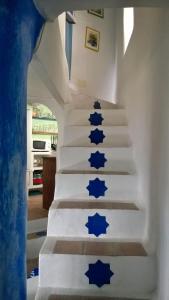 Un escalier avec des étoiles bleues peintes sur les escaliers dans l'établissement La Muralla, à Yunquera