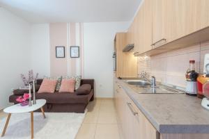 a kitchen and a living room with a couch at Fora Apartments in Dubrovnik