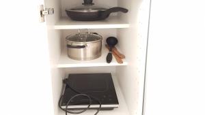 a kitchen shelf with a pot and a stove at Irmos Apartamentai salia Klaipedos in Toleikiai