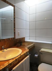 a bathroom with a sink and a toilet and a mirror at Apartamento Terra Amata Arica in Arica