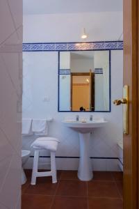 a bathroom with a sink and a toilet and a mirror at Hotel El Molino in A Guarda