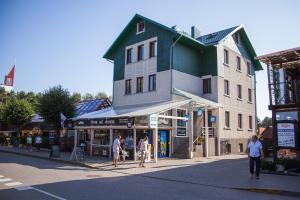 a building on a street with people walking in front of it at Akmuo Ant Akmens in Šventoji