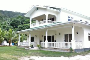 una casa blanca con un porche envolvente en Julie's Holiday Home, en Pointe Au Sel 