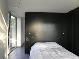 a bedroom with a bed with a black wall at Le studio Florent in Lannion