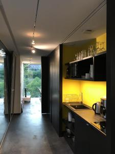 a kitchen with a counter and a yellow wall at Le studio Florent in Lannion