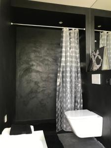 a black bathroom with a sink and a shower at Le studio Florent in Lannion