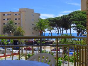 a balcony with a table and chairs and palm trees at CYE 5 Rentalmar in La Pineda