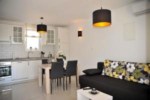 a living room and kitchen with a couch and a table at APP Rab Banjol 217 in Banjol