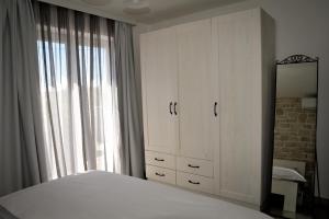 um quarto com uma cama branca e um espelho em APP Rab Banjol 217 em Banjol